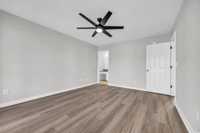 unfurnished room with ceiling fan, wood finished floors, and baseboards