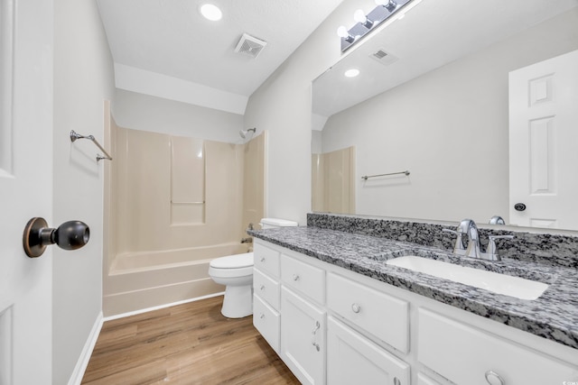 bathroom with toilet, visible vents, wood finished floors, and vanity