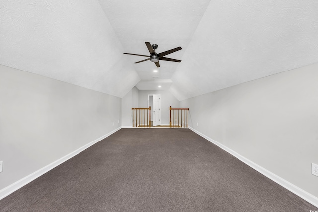 additional living space with a textured ceiling, ceiling fan, vaulted ceiling, and baseboards