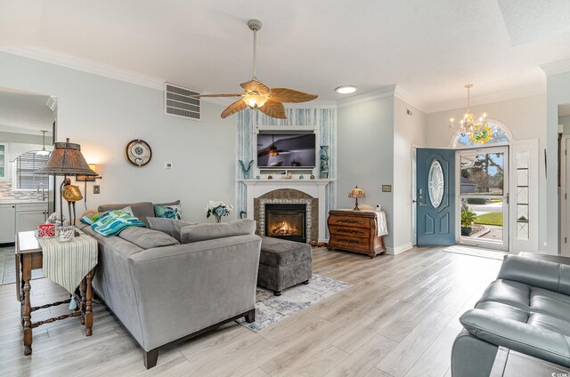 living room featuring ornamental molding, sink, light wood-type flooring, and a wealth of natural light