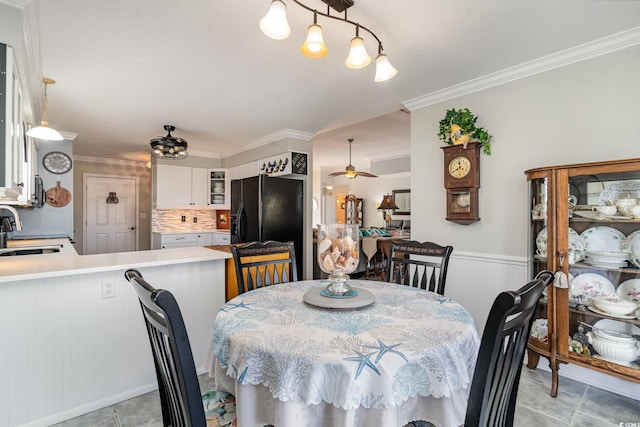 dining space with sink, crown molding, and ceiling fan