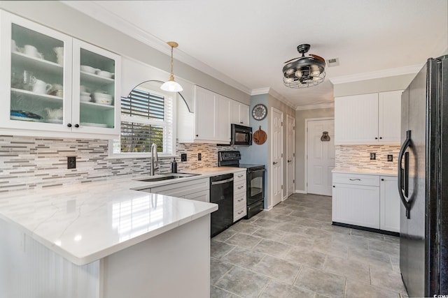 kitchen with sink, white cabinetry, hanging light fixtures, black appliances, and kitchen peninsula