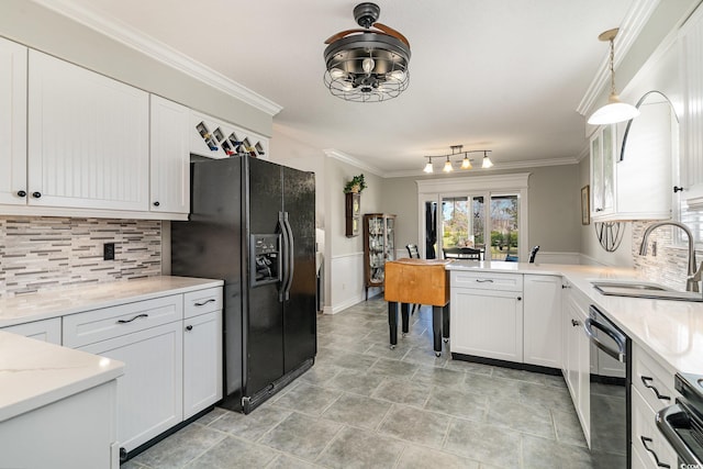 kitchen with hanging light fixtures, black appliances, sink, and white cabinets