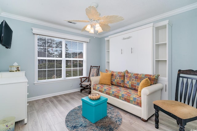 living room with crown molding, ceiling fan, and light hardwood / wood-style flooring