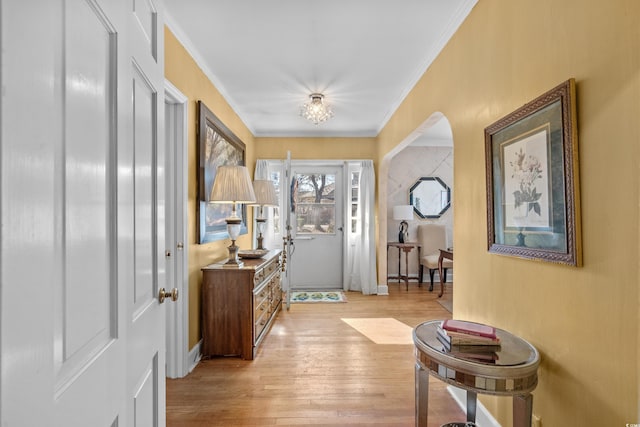 foyer with crown molding and light hardwood / wood-style flooring