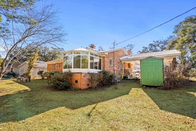 rear view of property featuring a yard and a sunroom