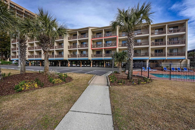 view of property featuring a community pool and fence