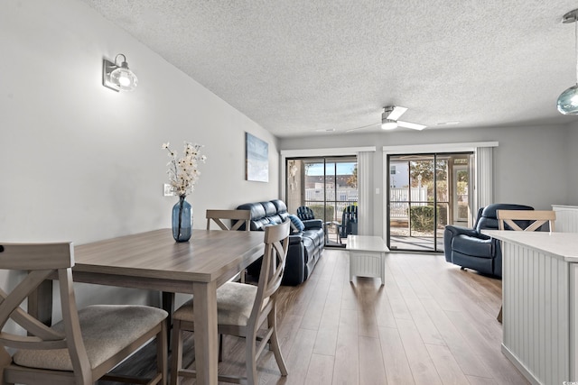 dining room featuring ceiling fan, light hardwood / wood-style flooring, and a textured ceiling