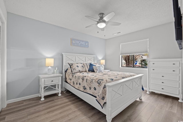 bedroom with wood-type flooring, ceiling fan, and a textured ceiling