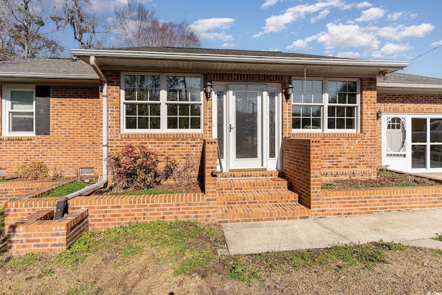 property entrance with brick siding and crawl space