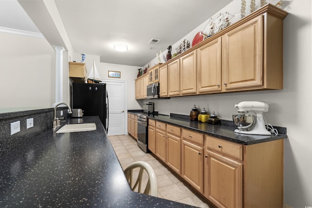 kitchen with light tile patterned floors, appliances with stainless steel finishes, sink, and ornate columns