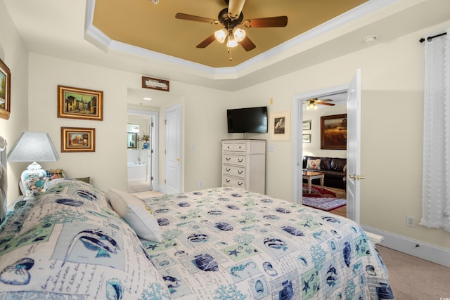 bedroom featuring ceiling fan, ensuite bath, a raised ceiling, and light carpet