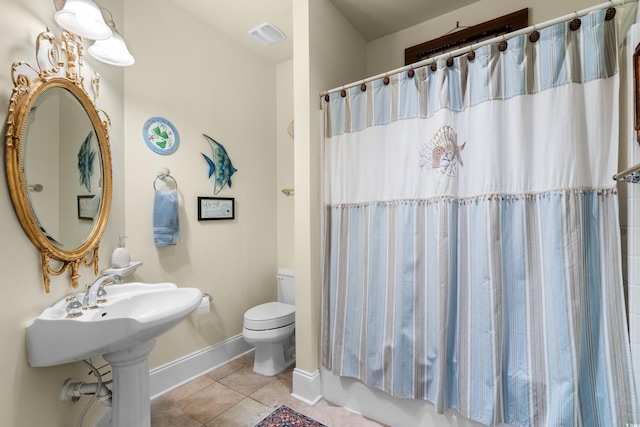 bathroom featuring tile patterned flooring, shower / tub combo, and toilet