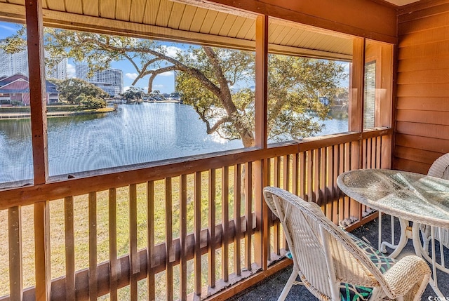 unfurnished sunroom featuring a water view