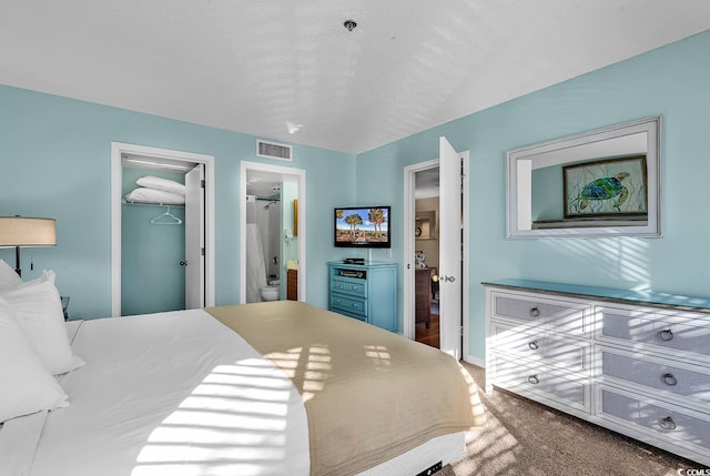 carpeted bedroom with connected bathroom, a spacious closet, a closet, and a textured ceiling