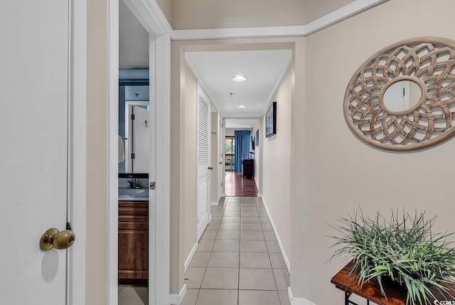 corridor with light tile patterned flooring and sink