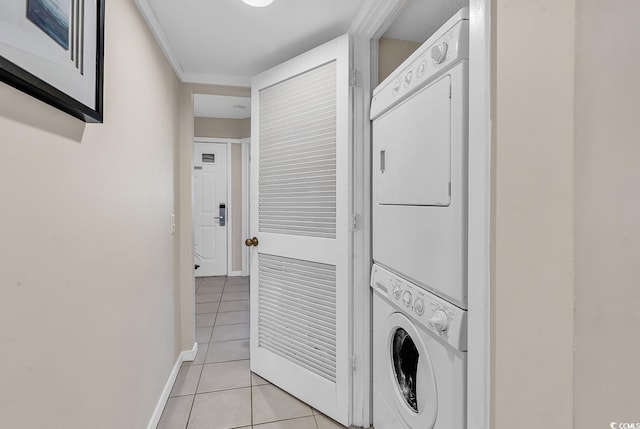 laundry room featuring stacked washer and dryer and light tile patterned floors