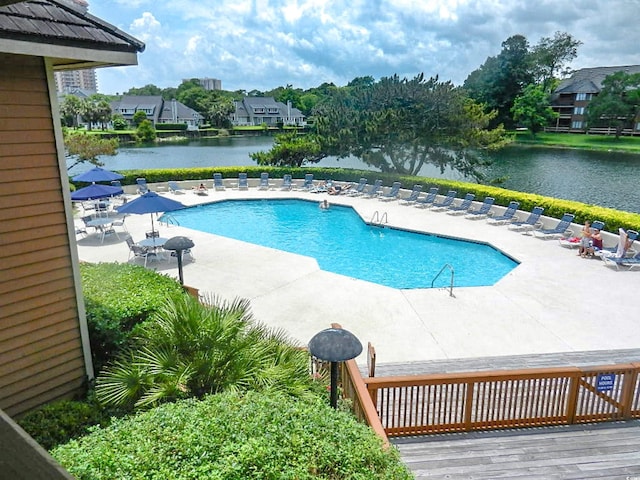 view of swimming pool featuring a deck with water view and a patio