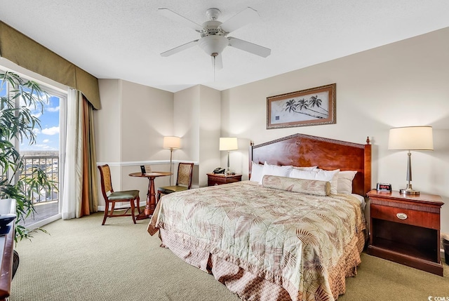 bedroom featuring ceiling fan, light carpet, access to exterior, and a textured ceiling