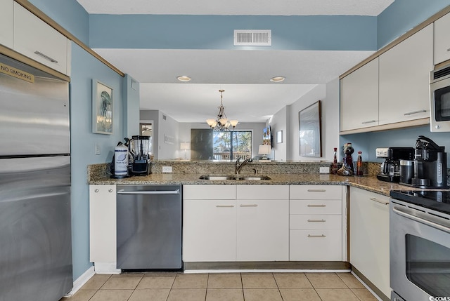 kitchen featuring stainless steel appliances, light tile patterned flooring, sink, and white cabinets