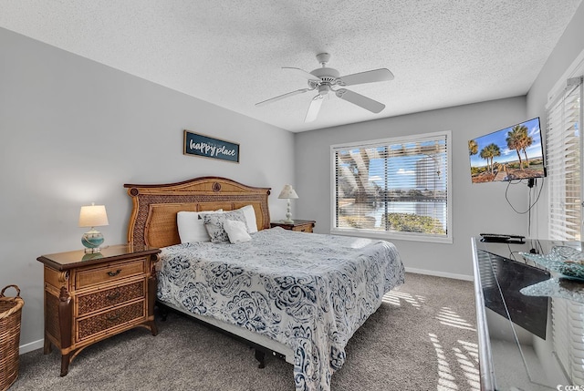 carpeted bedroom featuring ceiling fan and a textured ceiling