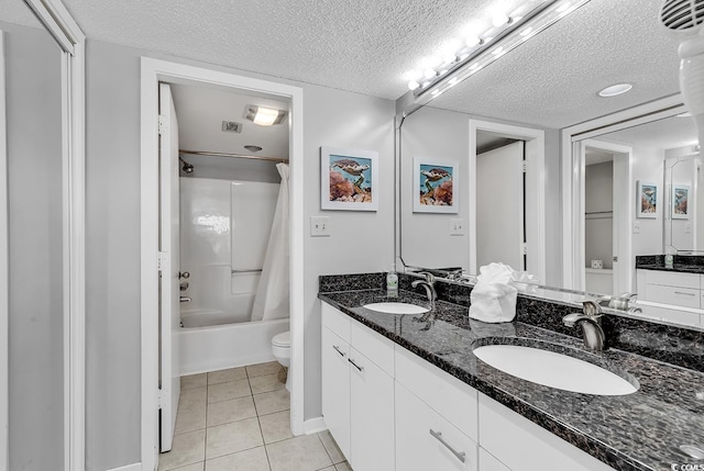 full bathroom featuring shower / tub combo with curtain, vanity, a textured ceiling, tile patterned floors, and toilet