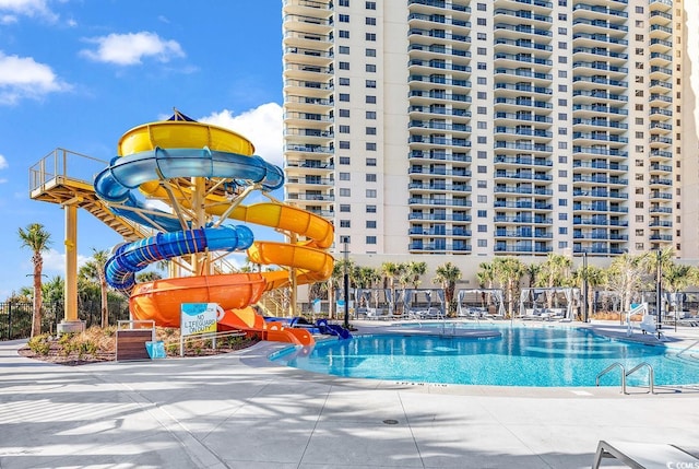 view of pool featuring a water slide and a patio area