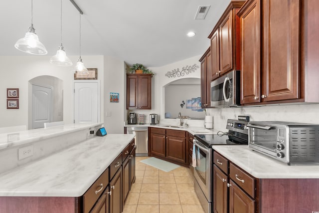 kitchen with a kitchen island, appliances with stainless steel finishes, decorative light fixtures, sink, and light tile patterned floors