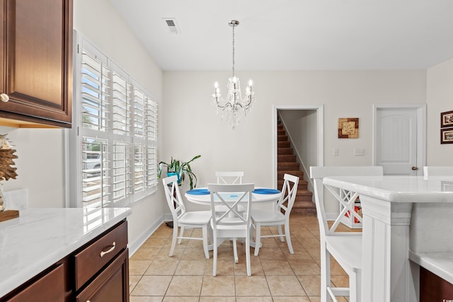 tiled dining room featuring an inviting chandelier