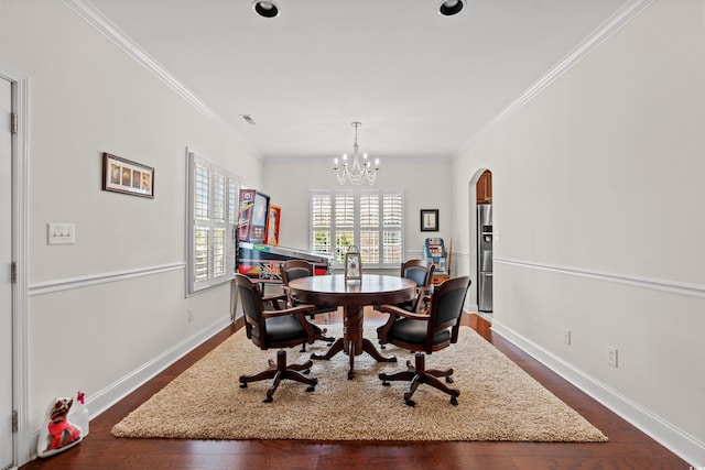 dining area with ornamental molding, dark hardwood / wood-style floors, and an inviting chandelier