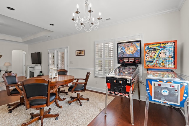 office featuring a notable chandelier, ornamental molding, dark hardwood / wood-style floors, and a raised ceiling