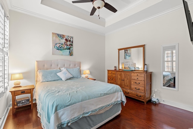 bedroom featuring dark hardwood / wood-style floors, ornamental molding, and a tray ceiling