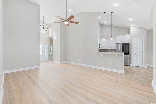 unfurnished living room featuring high vaulted ceiling, ceiling fan, and light hardwood / wood-style flooring