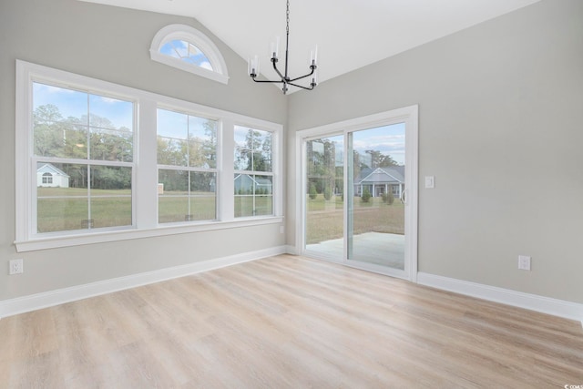 unfurnished dining area with vaulted ceiling, a notable chandelier, and light hardwood / wood-style flooring