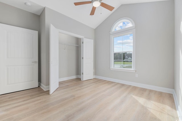 unfurnished bedroom with multiple windows, light hardwood / wood-style flooring, lofted ceiling, and a closet