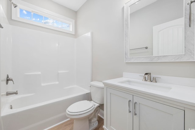 full bathroom with hardwood / wood-style flooring, vanity, shower / washtub combination, and toilet