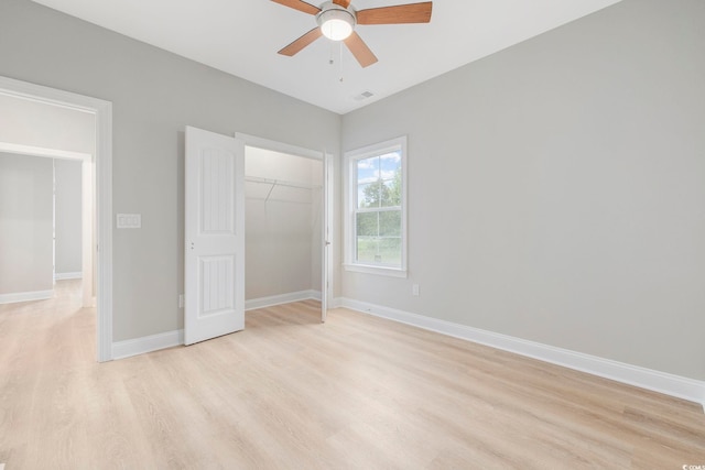 unfurnished bedroom with ceiling fan, light wood-type flooring, and a closet