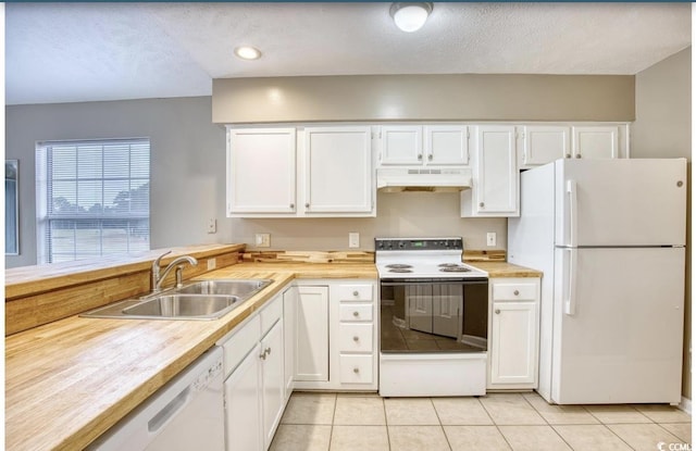 kitchen with light tile patterned floors, white cabinetry, a sink, white appliances, and under cabinet range hood