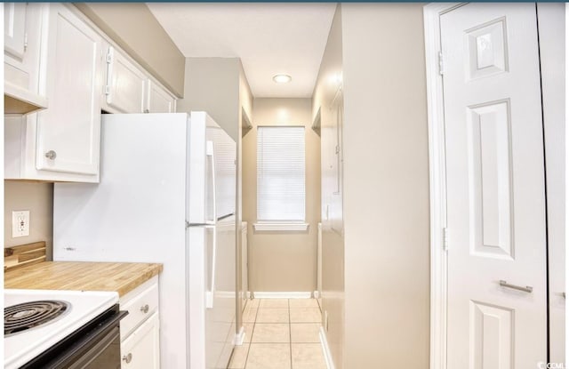 kitchen featuring light tile patterned flooring, white appliances, white cabinetry, baseboards, and light countertops