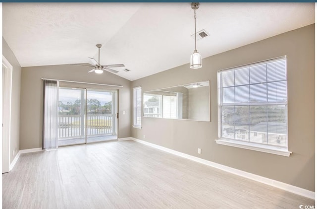 unfurnished room featuring lofted ceiling, visible vents, ceiling fan, wood finished floors, and baseboards