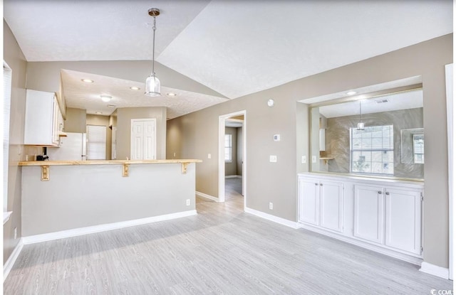 unfurnished living room featuring vaulted ceiling, recessed lighting, light wood-style flooring, and baseboards