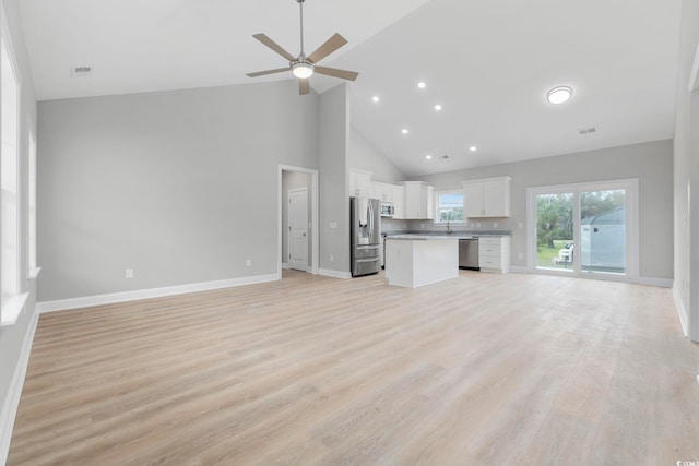 unfurnished living room featuring ceiling fan, sink, high vaulted ceiling, and light wood-type flooring