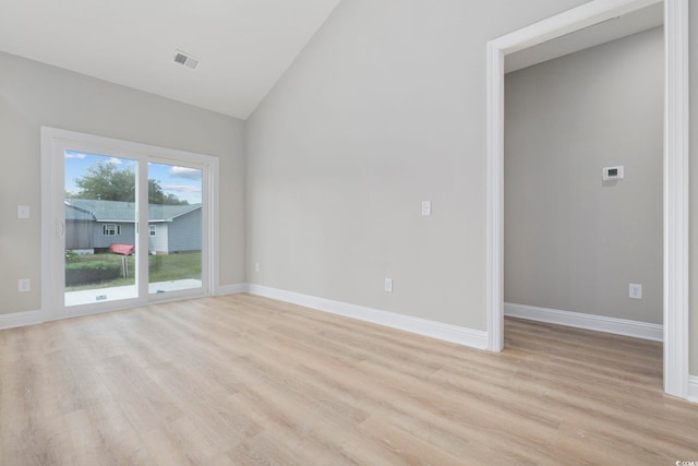 empty room with lofted ceiling and light hardwood / wood-style floors