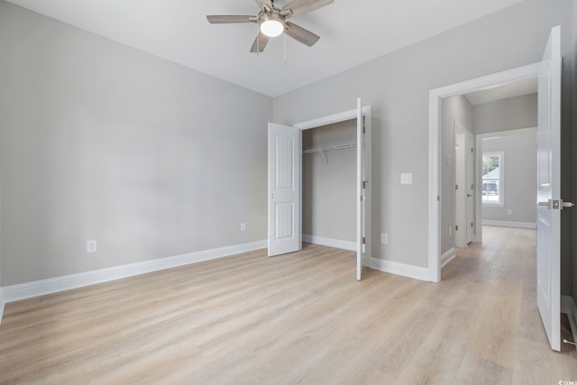 unfurnished bedroom with ceiling fan, light wood-type flooring, and a closet