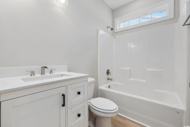 full bathroom featuring hardwood / wood-style flooring, shower / washtub combination, vanity, and toilet