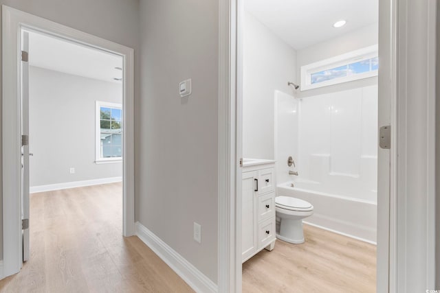 full bathroom with hardwood / wood-style flooring,  shower combination, toilet, and vanity