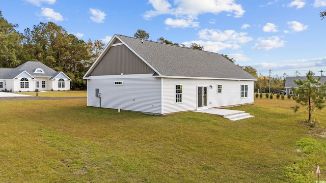 rear view of property featuring a lawn