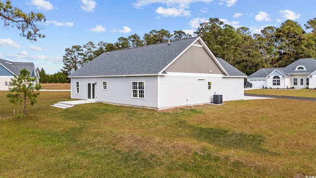 rear view of house with a lawn and central air condition unit