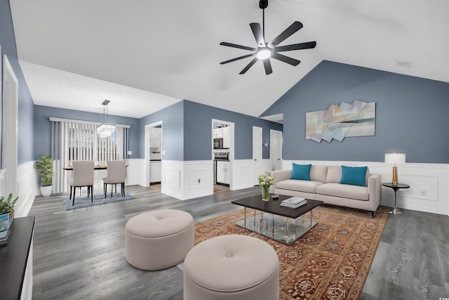 living room with dark hardwood / wood-style flooring, ceiling fan with notable chandelier, and vaulted ceiling