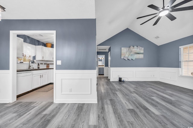 living room with sink, wood-type flooring, ceiling fan, and vaulted ceiling